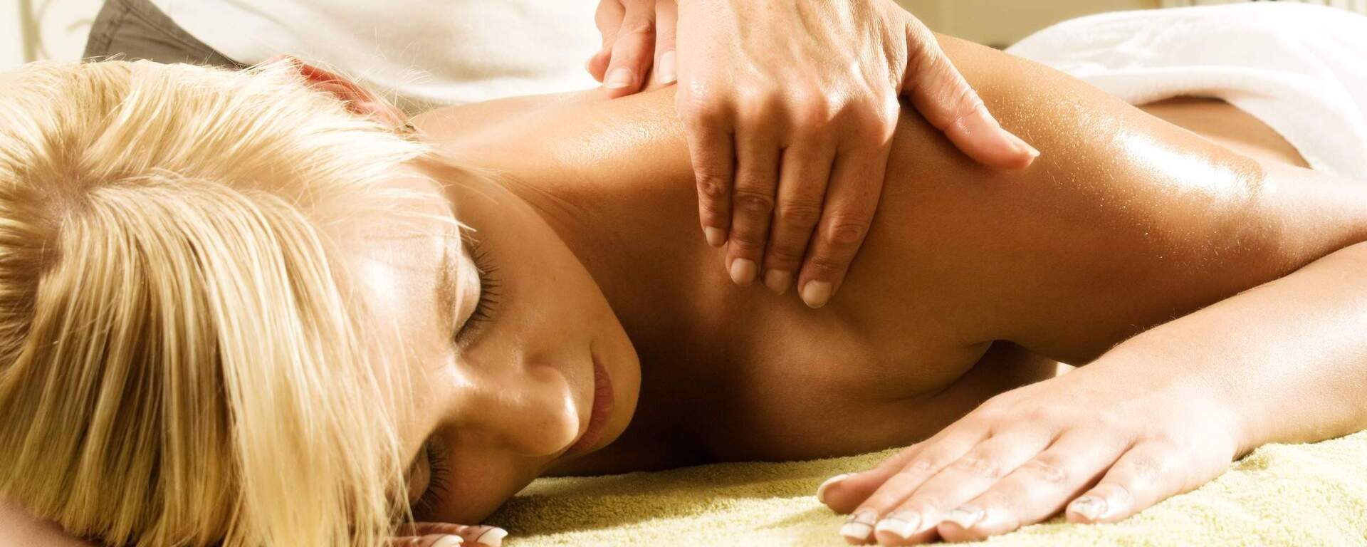 Eine Frau erhält eine Massageanwendung im Wellnessbereich des Hotels in Bodenmais